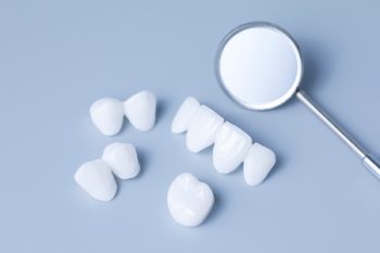 Dental Mirror And Dentures On A Light Blue Background